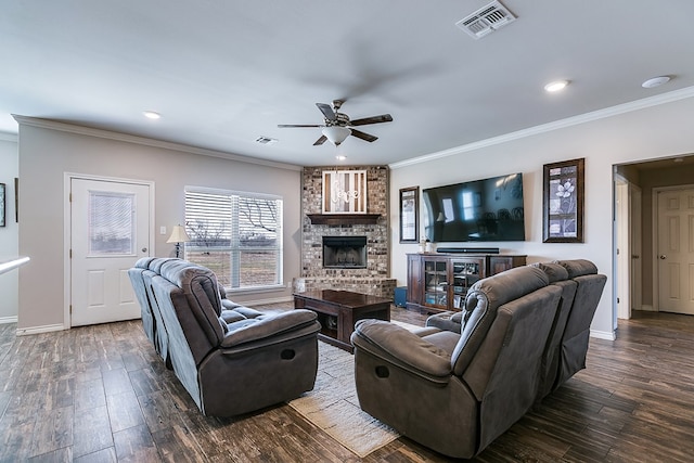 living room with dark wood-type flooring, a fireplace, crown molding, and ceiling fan