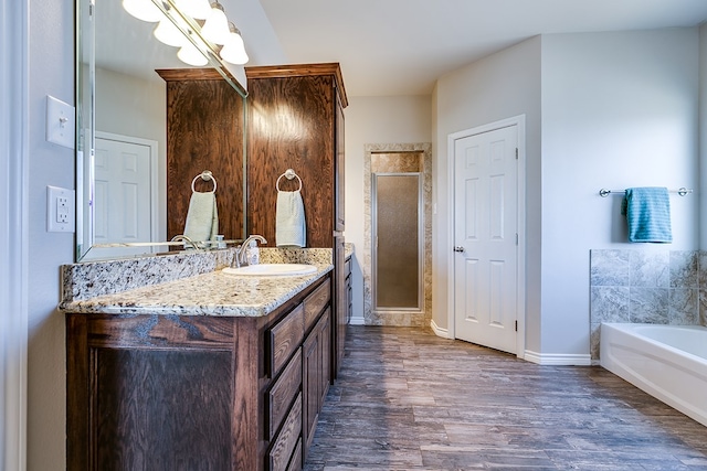 bathroom with vanity, hardwood / wood-style flooring, and independent shower and bath