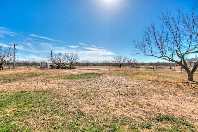 view of yard featuring a rural view and a storage unit