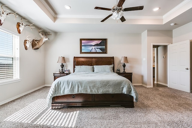 carpeted bedroom featuring crown molding, ceiling fan, and a raised ceiling