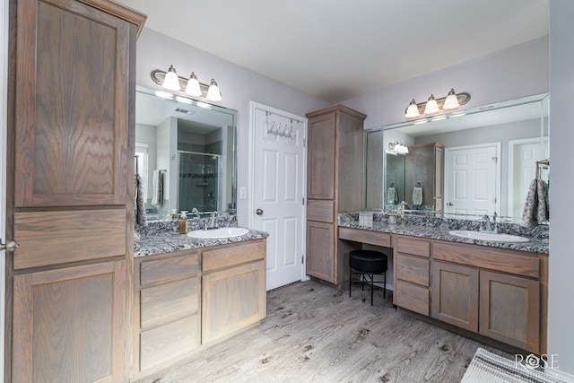 5033 Scarlet Oak Ln, San Angelo, TX 76904 - bathroom featuring a stall shower, two vanities, and wood finished floors