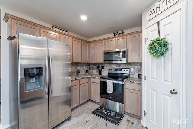 5033 Scarlet Oak Ln, San Angelo, TX 76904 - kitchen featuring stainless steel appliances, tasteful backsplash, light stone counters, and light wood-style floors