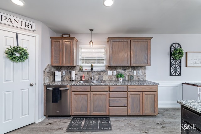 5033 Scarlet Oak Ln, San Angelo, TX 76904 - kitchen featuring stainless steel dishwasher, a sink, decorative backsplash, and light wood-style floors