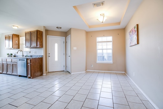 2902 Freeland St, San Angelo, TX 76901 - kitchen featuring dishwasher, a sink, baseboards, light tile patterned flooring, and brown cabinets