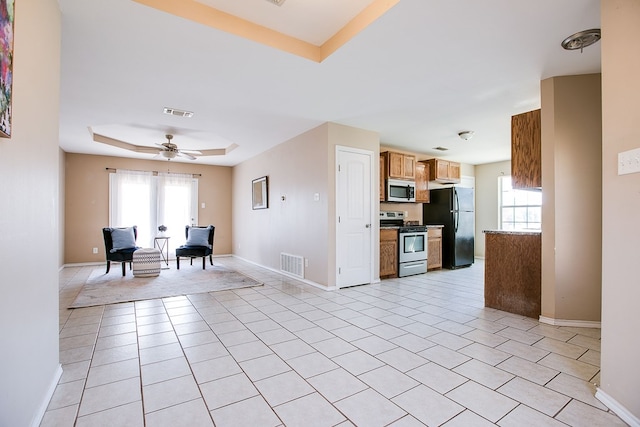 2902 Freeland St, San Angelo, TX 76901 - kitchen featuring stainless steel appliances, a raised ceiling, healthy amount of natural light, and baseboards