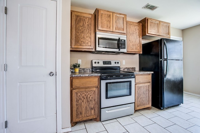 2902 Freeland St, San Angelo, TX 76901 - kitchen featuring stainless steel appliances, light tile patterned floors, and brown cabinets