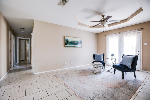 2902 Freeland St, San Angelo, TX 76901 - living area featuring light tile patterned flooring, a ceiling fan, a tray ceiling, and baseboards