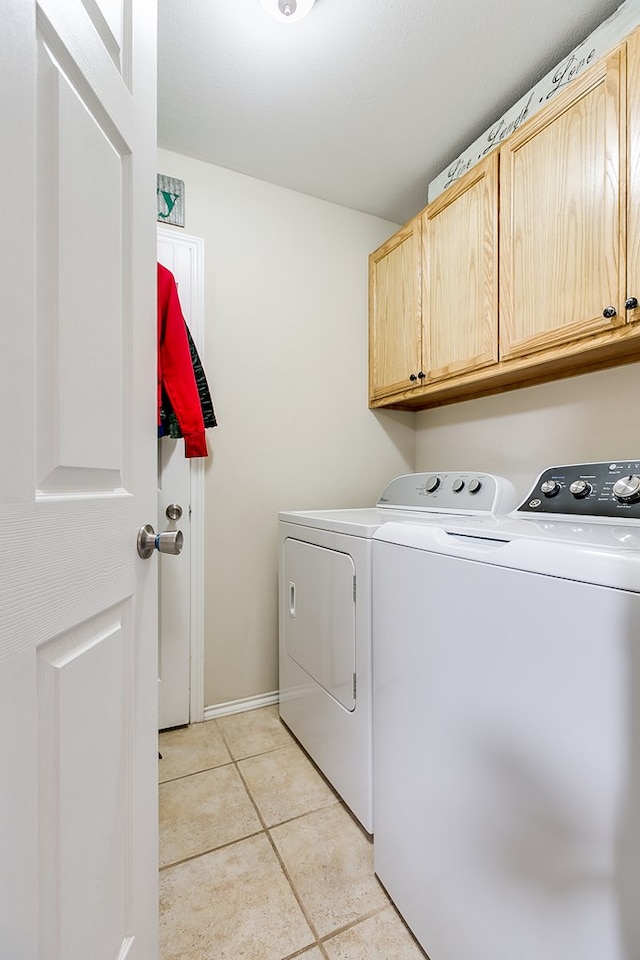 washroom featuring cabinets, washer and dryer, and light tile patterned floors