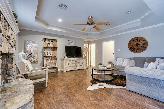 living room featuring dark wood-type flooring, ceiling fan, and a raised ceiling