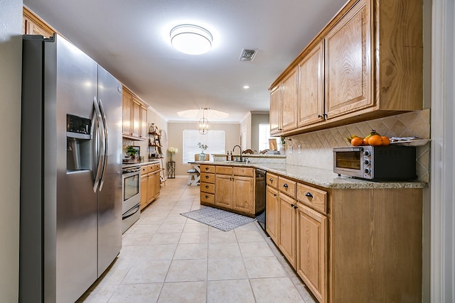 kitchen with tasteful backsplash, light tile patterned floors, ornamental molding, appliances with stainless steel finishes, and kitchen peninsula