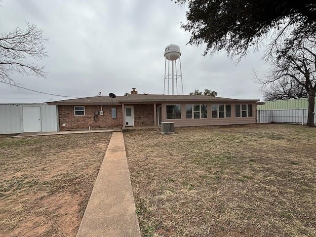 view of front of home featuring cooling unit and a front yard