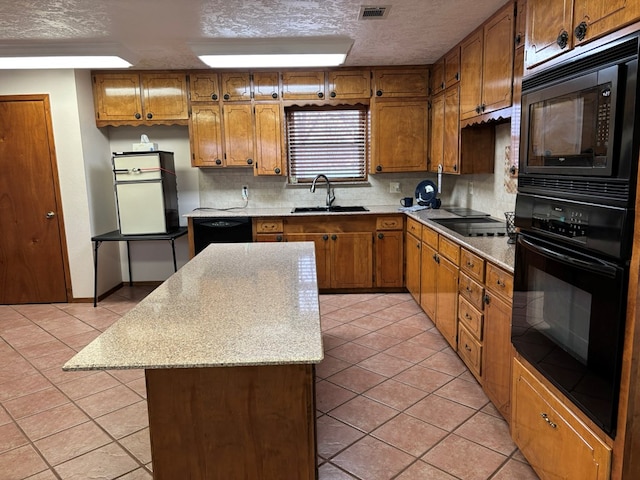 kitchen featuring light tile patterned flooring, tasteful backsplash, sink, a center island, and black appliances