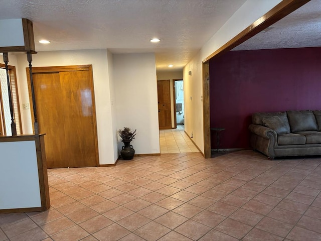 unfurnished living room featuring light tile patterned floors and a textured ceiling