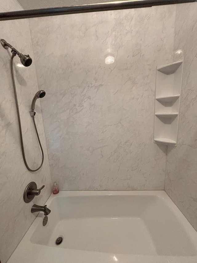 bathroom featuring tiled shower / bath