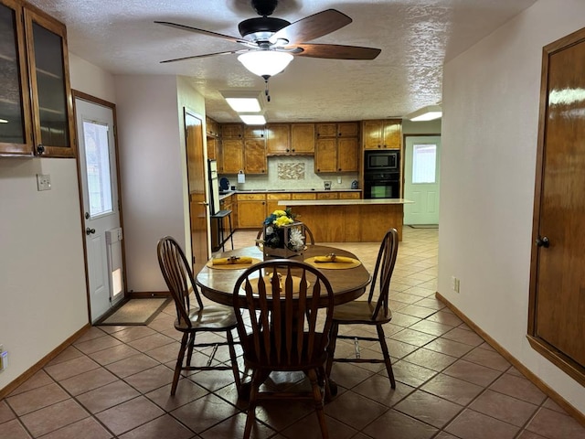 dining space featuring ceiling fan, tile patterned floors, and a textured ceiling