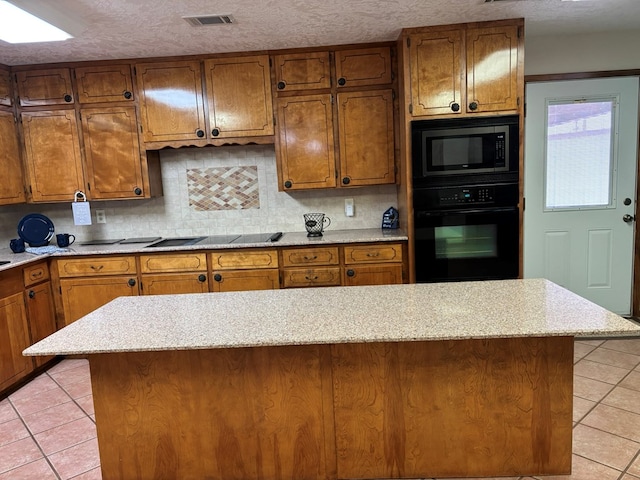 kitchen featuring light tile patterned floors, backsplash, black appliances, and a textured ceiling