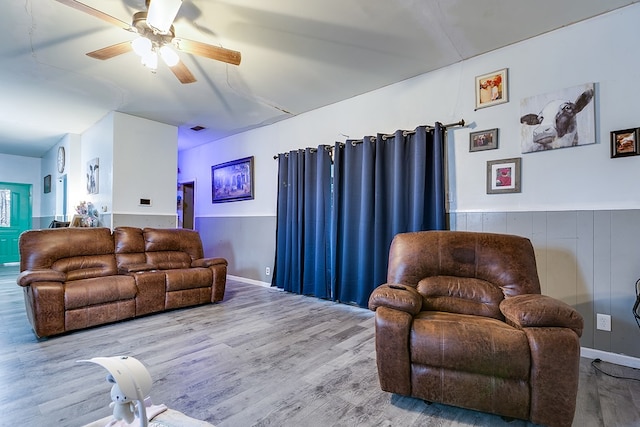 living room featuring wood-type flooring and ceiling fan