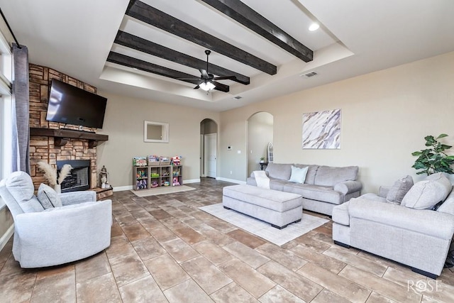 5922 Tarin St, San Angelo, TX 76904 - living room featuring arched walkways, a tray ceiling, beam ceiling, baseboards, and a ceiling fan