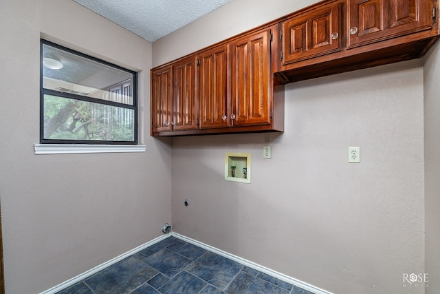 clothes washing area featuring cabinets, washer hookup, a textured ceiling, and electric dryer hookup