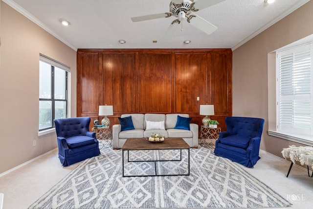 living room with ornamental molding, light carpet, ceiling fan, and a textured ceiling