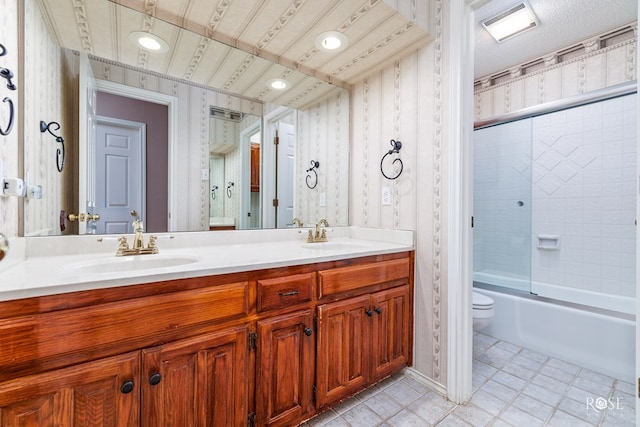 full bathroom featuring toilet, vanity, and bath / shower combo with glass door