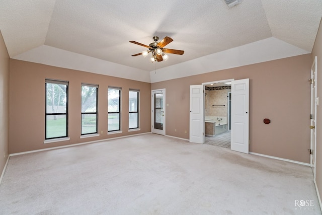 unfurnished bedroom featuring ceiling fan, connected bathroom, a raised ceiling, and light carpet