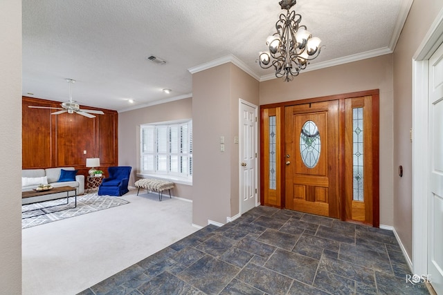 carpeted foyer entrance featuring crown molding, an inviting chandelier, and a textured ceiling