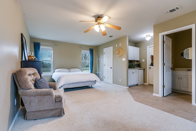 carpeted bedroom featuring ensuite bathroom and ceiling fan