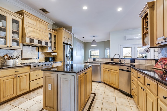 kitchen featuring light tile patterned flooring, appliances with stainless steel finishes, sink, a center island, and kitchen peninsula