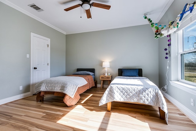 bedroom with crown molding, ceiling fan, and light hardwood / wood-style floors