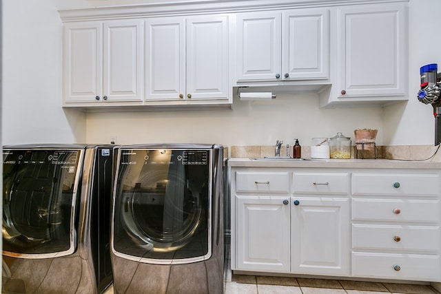 laundry area featuring cabinets, light tile patterned flooring, sink, and independent washer and dryer