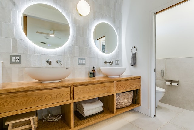 bathroom featuring toilet, tile walls, vanity, ceiling fan, and tile patterned flooring