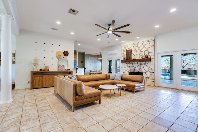 tiled living room featuring a wall mounted air conditioner, crown molding, french doors, and ornate columns