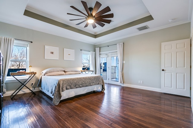 bedroom with multiple windows, a tray ceiling, and ceiling fan