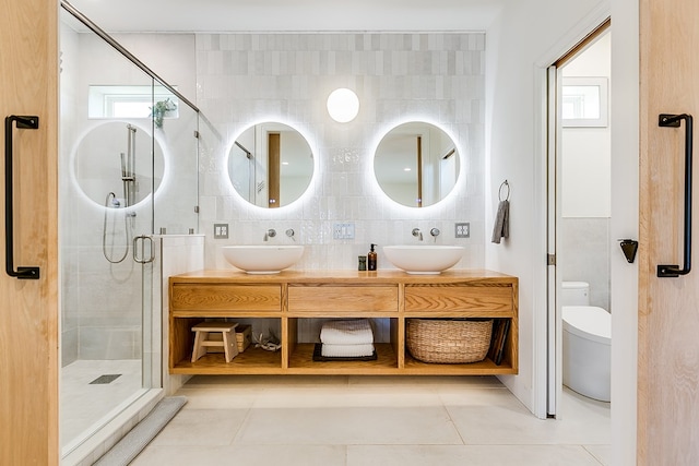 bathroom with backsplash, vanity, tile patterned floors, toilet, and walk in shower