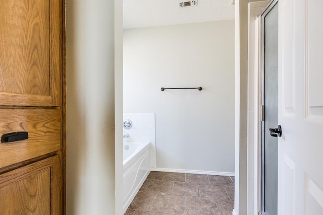 full bath featuring a stall shower, visible vents, baseboards, and a garden tub