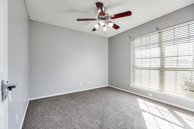 empty room with carpet floors, a ceiling fan, baseboards, and a textured ceiling