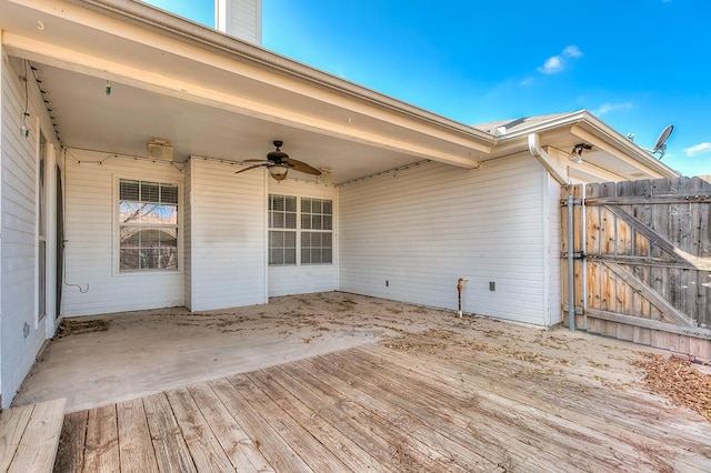 wooden terrace featuring a gate and a ceiling fan