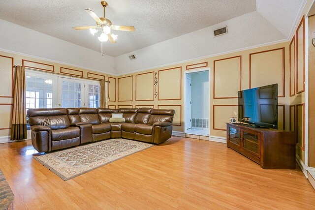 living room featuring vaulted ceiling, french doors, ceiling fan, and light wood-type flooring