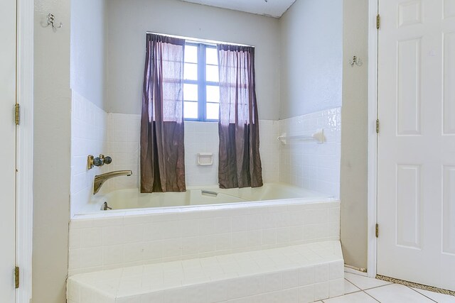 bathroom featuring tile patterned flooring and a relaxing tiled tub