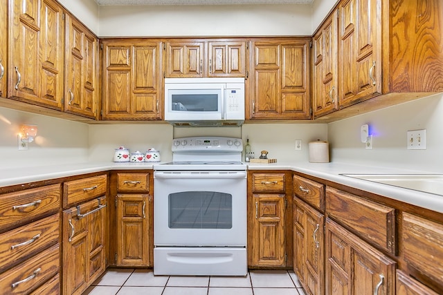 kitchen featuring white appliances and light tile patterned flooring