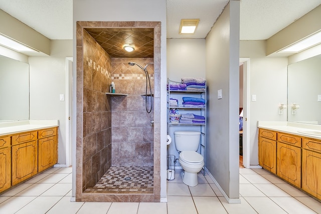 bathroom with tile patterned floors, vanity, and a tile shower