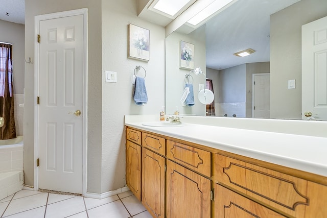 bathroom featuring tile patterned floors, a skylight, and vanity