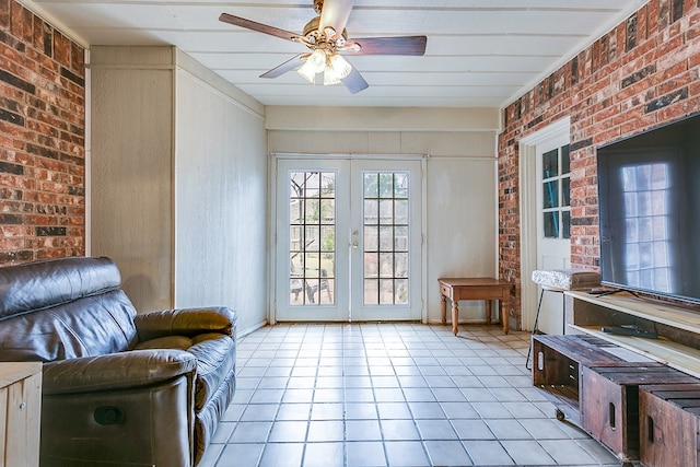 interior space featuring light tile patterned flooring, french doors, ceiling fan, and brick wall