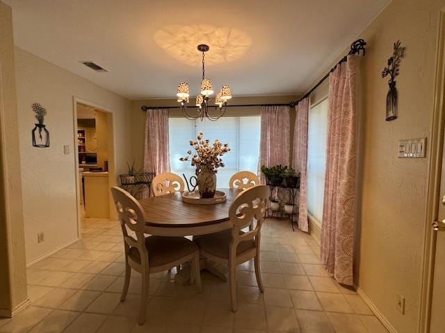 dining room with plenty of natural light, light tile patterned floors, and a notable chandelier