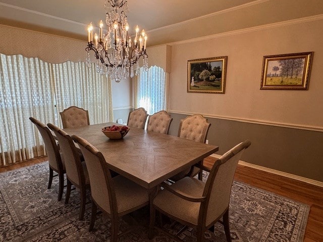 dining room with dark wood-type flooring, a healthy amount of sunlight, crown molding, and a chandelier