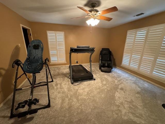 workout room with ceiling fan and light colored carpet