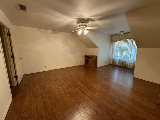 bonus room with lofted ceiling, dark hardwood / wood-style floors, and ceiling fan