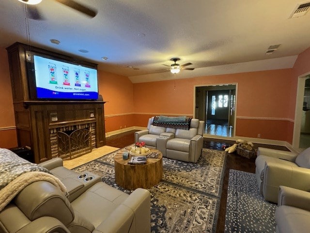 living room with lofted ceiling, a brick fireplace, and ceiling fan