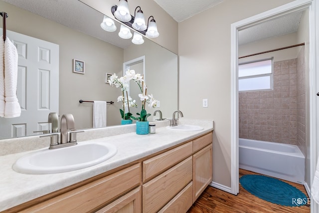 bathroom featuring vanity, wood-type flooring, bathtub / shower combination, and a textured ceiling